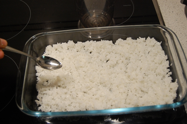 colocar arroz en bandeja y echar aliño sushi